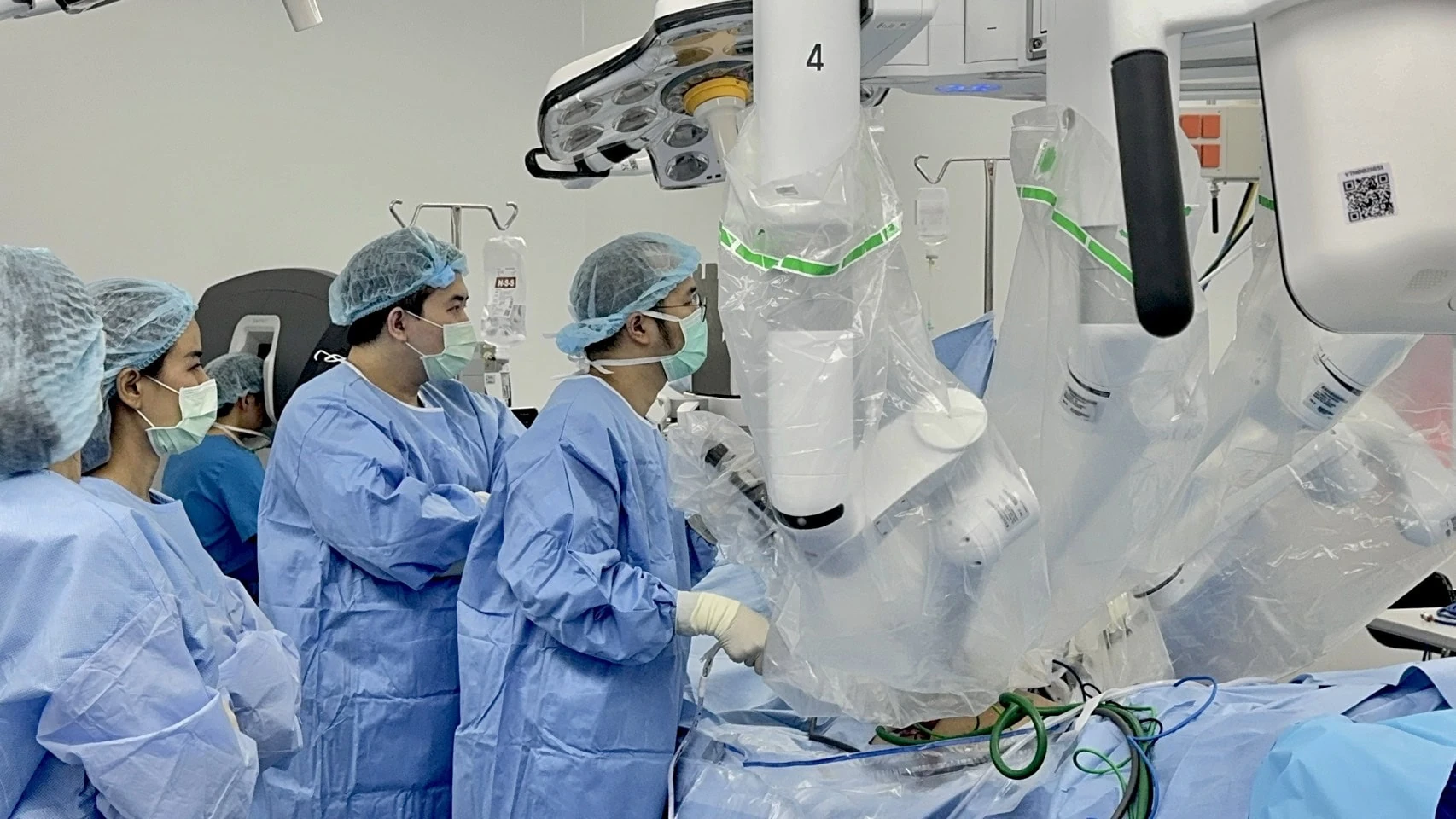 Vejthani specialists stand beside the Da Vinci surgical robot in the operating room